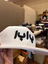 a white snapback hat with black letters on it